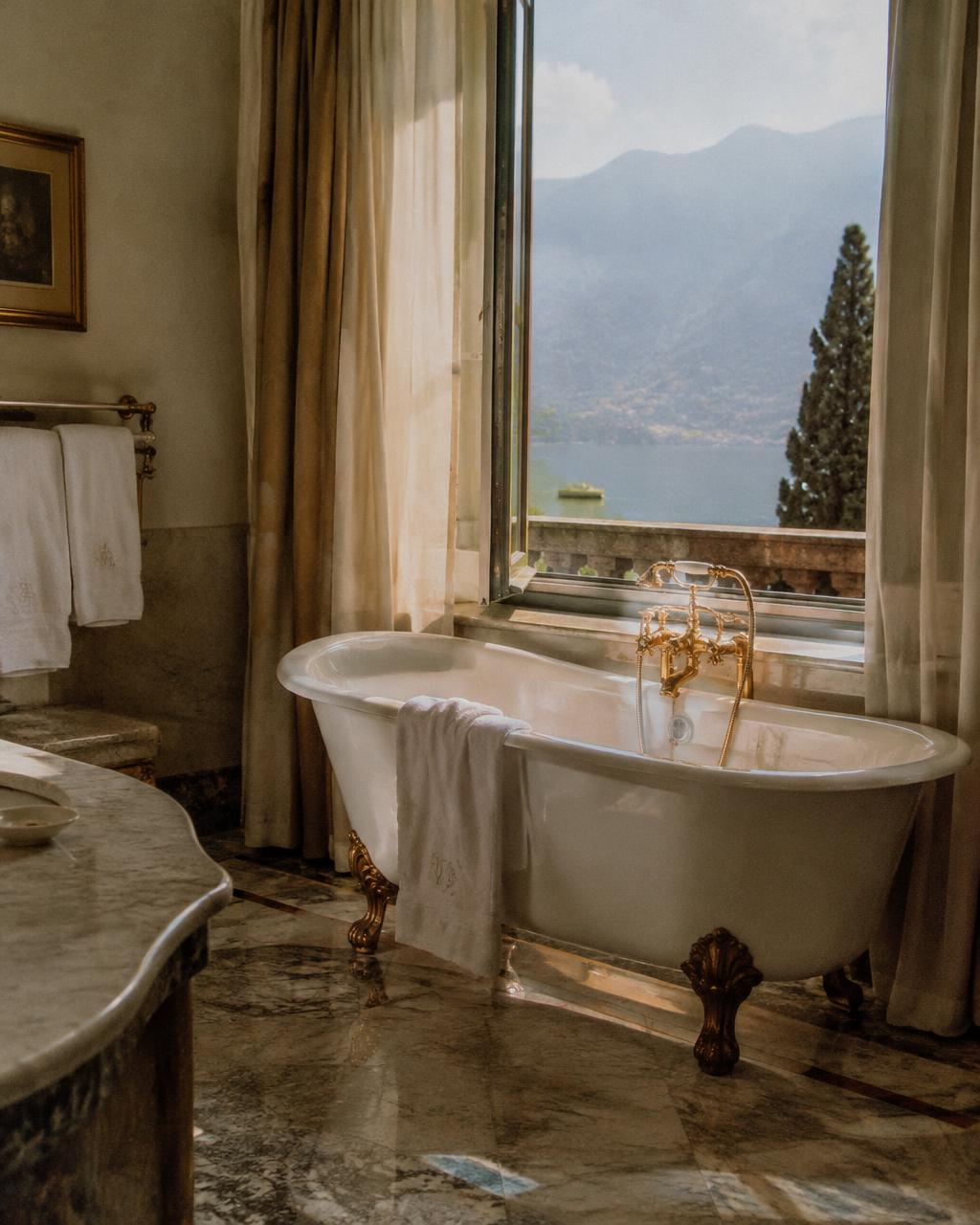 Freestanding bath before a window onto the lake